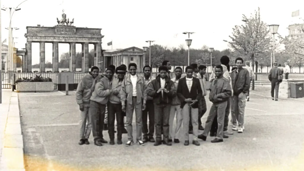 Eine Gruppe junger Männer steht vor dem Brandenburger Tor in Berlin