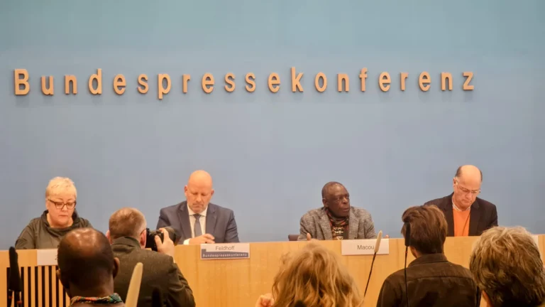 Evelyn Zupke (links), David Macou und Michael Windfuhr (rechts) auf dem Podium der Bundespressekonferenz, 30. September 2024