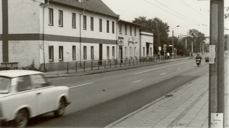Straße vor dem Hüttengasthof in Eberswalde, im Vordergrund fährt ein Trabant, 1991